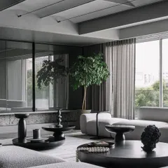 Another perspective of the living room, emphasizing the abundant natural light and the integration of indoor plants to add life to the monochromatic scheme.