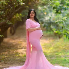 This serene solo portrait captures the beauty and grace of motherhood. The soft, natural lighting of the garden setting enhances the peaceful mood of the moment.