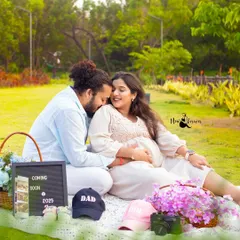 A perfect picnic setup for a pregnancy announcement. The letterboard, sonogram, and little "Mom" and "Dad" hats make this such a sweet and personal outdoor scene.