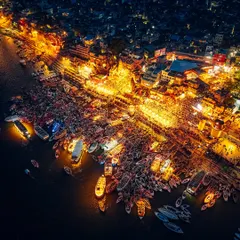 The Ganga Aarti at Dashashwamedh Ghat in Varanasi, seen from the sky. At night, the ghat transforms into a sea of light and devotion. This drone shot captures the thousands of devotees and boats gathered to witness the ceremony, a truly spiritual spectacle that connects you to something ancient and divine.