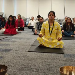 A group of employees from Hewlett Packard Enterprise meditating peacefully on their mats during a sound healing and breathwork session.