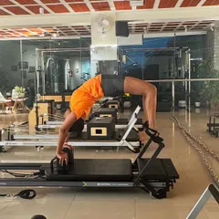Let's get flexible. This full backbend, or wheel pose, on the reformer demonstrates incredible spinal mobility and shoulder strength.