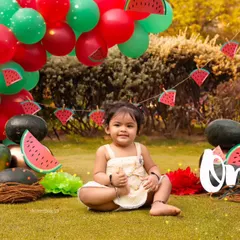 A fun watermelon-themed first birthday shoot in the park, perfect for a summer baby.