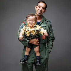 An adorable portrait of a father holding his son. The little one's joyful expression shows the fun they have together.