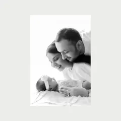 Stripped of color, this close-up of new parents admiring their baby is incredibly powerful. Every detail, from their soft smiles to the baby's tiny form, tells a story of love.