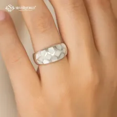 This modern honeycomb silver ring features a unique geometric pattern with white enamel inlay. Its wide band and bold design make it a contemporary statement piece.