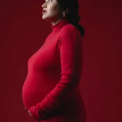 A bold and powerful statement. A simple, form-fitting red dress against a matching red background creates a stunning monochrome color portrait.