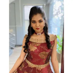 A full sangeet or reception look for a model shoot, featuring a dramatic eye, bold red lip, and a sculpted hairstyle. The makeup is designed to complement the ornate, off-the-shoulder gown.