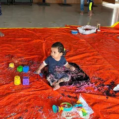 This baby is fully immersed in a tray of colorful, taste-safe noodles. For this age group, I ensure all materials are safe if they end up in the mouth, so they can explore without worry.