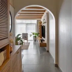 The foyer in 'Cover me in Sunshine' greets you with a graceful archway. The space combines style and function with an integrated shoe cabinet, mirror, and a comfortable seater, all finished in a light white oak.