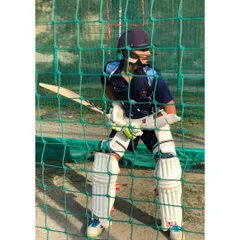 A young batsman fully padded and focused during a net session. This is where technique is perfected and confidence is built, one ball at a time.