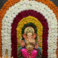A vibrant rainbow arch made from concentric rings of marigolds and chrysanthemums in different colors. This design creates a joyful and colorful aura, perfect for a lively Ganpati celebration.