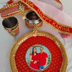 I create bespoke Karwa Chauth pooja sets like this one. This traditional red and gold set is fully personalized with a couple's photo on the thali, and matching designs on the chhalni (sieve), lota (water pot), and glass.