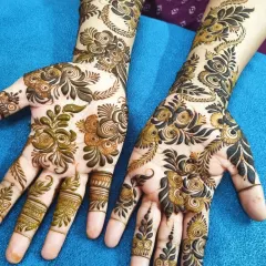 I love the grace of a beautiful Arabic henna design. This style features bold floral and vine motifs that flow elegantly across the hands, leaving some open skin for a striking contrast. It's a perfect choice for a sophisticated party look.