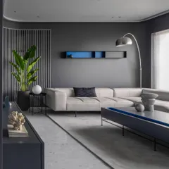 The living room, where a slatted partition and a large plant soften the space, and a hint of blue appears in the wall shelf and cushions.