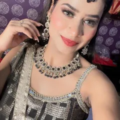A close-up selfie showing off a beautiful black and silver rental jewellery set. It includes a choker, matching earrings, and a maang tikka, perfect for a sangeet or reception.