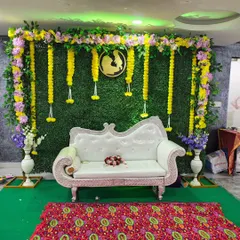 I also design elegant setups for baby showers. This one features a lush green wall backdrop, traditional marigold garlands, and a classic white diwan for the mother-to-be, perfect for photos.
