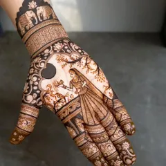 A classic Karwa Chauth design featuring a woman looking through the sieve. This kind of figure work is my specialty, and I make sure to capture the feeling of the festival in the mehandi.
