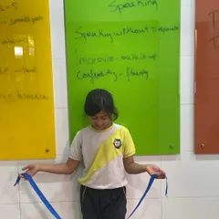 Impromptu speaking doesn't require complex preparation. Here, a student uses a simple blue ribbon as a stimulus to create a spontaneous speech, proving that any object can spark creativity and confident speaking.