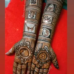 A complete bridal story told on the hands. This design features detailed portraits of the couple, surrounded by traditional wedding symbols like Lord Ganesha, a doli, shehnai, and kalash, making it a true narrative piece.