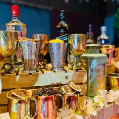 The rich textures and colors of the Gatsby theme. This shot highlights the metallic pineapple-stemmed goblets and copper mugs, filled with star anise and dried citrus, ready for crafting exquisite 1920s-inspired cocktails.