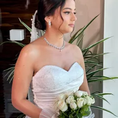 Beracah holding her bouquet of white roses. Her complete look, from the delicate veil to the soft makeup, is a perfect example of timeless Christian bridal beauty.