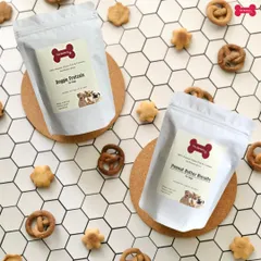 A beautiful flat lay of my Doggie Pretzels and Peanut Butter Biscuits. These treats are scattered on a clean, modern background, showing off their handmade quality and wholesome appeal.