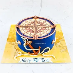 A nautical-themed cake perfect for a seasoned traveler. The design features a detailed compass on top and a fully hand-modelled anchor, all set against a world map base.
