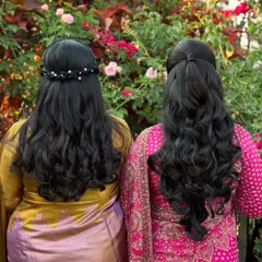 A view of the elegant hairstyles for the mother and daughter. One chose a half-up style with pearl accessories, while the other opted for a simple, classic half-updo.
