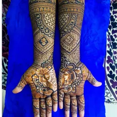 This elegant bridal design features intricate portraits of the bride and groom, framed by beautiful leafy patterns. The arms are covered in geometric and traditional patterns, creating a rich and cohesive look.