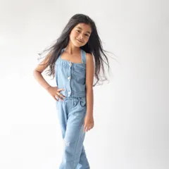 A confident and cool pose from this six-year-old in a simple denim jumpsuit. The clean white background makes her personality pop.