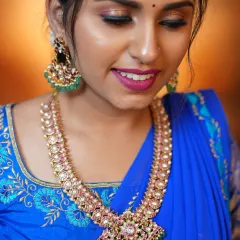 A close-up of a beautiful Jadau set, perfect for a Mehendi event or a semi-bridal look. The combination of pink and green stones against the royal blue saree is just stunning.