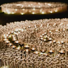Artistry is at the core of what we do. For this event, we created a breathtaking outdoor installation featuring a field of countless candles and delicate white blooms, designed to evoke a sense of wonder and create an ethereal, glowing landscape under the night sky.