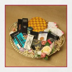 A beautiful makeup hamper presented on a golden, heart-shaped tray. This collection includes products from Lakmé, Recode, and other popular brands, surrounded by delicate floral decorations.