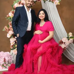 A happy and classic portrait of the expecting couple. Posed against a floral arch, this shot captures their shared excitement and the beauty of their journey together.