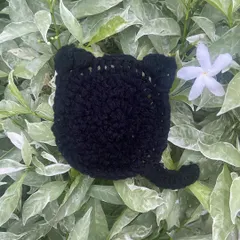 A close-up of my black cat coaster, perfect for your desk. It has little ears and a tail, and it's one of my favorite things to make.