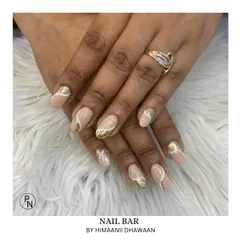 A chic design with a nude base, gold glitter, and delicate white swirls for a modern and artistic look.