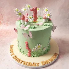 We create an enchanted forest for a first birthday with this magical fairy cake. A lush green canvas is home to whimsical mushrooms, delicate daisies, and fluttering butterflies, creating a storybook setting for a one-year-old's special day.