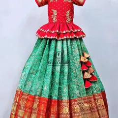 A beautiful Banarasi lehenga in red and green. The red peplum top has delicate embroidery, and the green skirt has a traditional red and gold border.