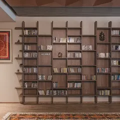 We designed this 'Library of Music' for a client with an extensive collection. The custom-built wooden bookshelf features an irregular, geometric pattern, turning a storage unit into a sculptural art piece that reflects the owner's passion.
