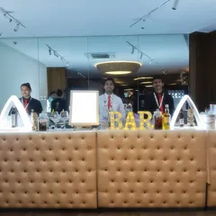 A full view of the beige tufted bar, showing its modular design that can be adjusted to fit different venue sizes.