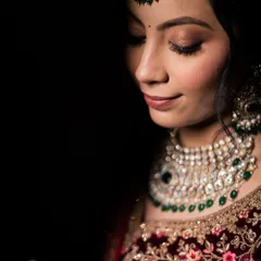 A dramatic close-up of a bride's emerald and polki necklace against a black background. Jewelry isn’t just an accessory; it’s a part of your heritage and story.