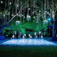 I transformed this outdoor space into an enchanted forest for a cocktail party. A custom dance floor sits under a canopy of trees, with cascading fairy lights and hanging floral arrangements that create a magical, starlit atmosphere for an evening of celebration.