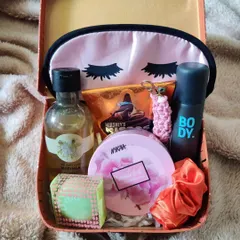 A cozy and compact hamper for your sister or friend. This gift, packed in a reusable tin box, includes an eye mask, body spray, perfume, a Nykaa compact, and a Hershey's chocolate bar.