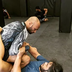 A close-up of a BJJ rolling session, working to pass the guard. This is a chess match of leverage and technique.