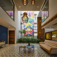 The heart of the Ashraya Residence is this double-height courtyard, where a 28-foot painting of Lord Krishna becomes a spiritual and visual anchor. The space is a modern interpretation of the traditional Indian 'aangan', filled with light, art, and life.