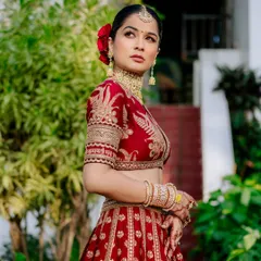 A timeless bridal portrait. I focus on capturing the bride's elegance and the intricate details of her wedding lehenga, like this stunning red Sabyasachi ensemble, creating a classic image she'll cherish forever.