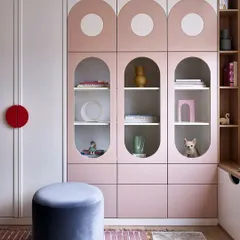This playful wardrobe design is perfect for a kids' room. It features curved shutters with circular glass cutouts and a soft pink and white color palette, combining fun aesthetics with practical storage.