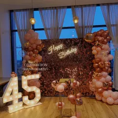 Milestone birthdays deserve a grand statement. For this 45th birthday, I created a stunning photo corner using large, light-up marquee numbers against a rose gold shimmer wall, framed by a matching balloon garland.