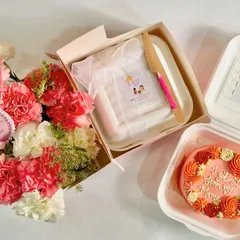 A beautiful flat-lay of our Mother's Day gift options. This includes a floral wreath bento cake and a flower box hamper, showcasing the elegant and coordinated gifting possibilities.